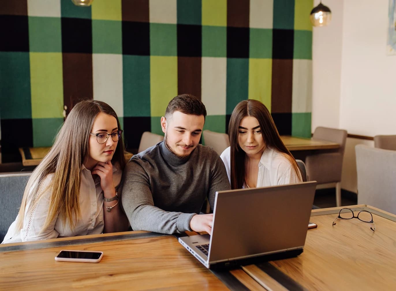 Team collaborating around a laptop